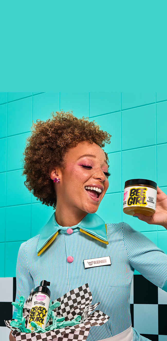 Person holding a product with 'Bee Girl' branding against a turquoise tiled wall.